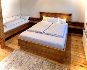 two twin beds in a room with wooden floors at Vogelbauer Apartments in Egling