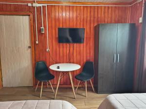 a room with a table and two chairs and a tv at Hostel Notro Valdivia in Valdivia +29 photos