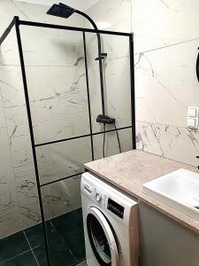 een wasmachine in een badkamer met een douche bij Apartment J&S nr 77, blisko Aquapark Reda, Trójmiasto in Rumia +3 foto's