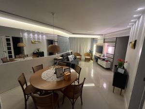 un salon et une salle à manger avec une table et un canapé dans l'établissement Melhor Apto no Centro ao lado da Praia e Comércio, à Guarapari