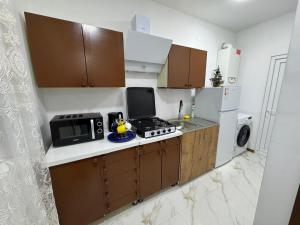 a small kitchen with a stove and a microwave at NAPO HOTEL სასტუმრო ნაპო in Zugdidi +33 photos