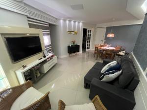 un salon avec un canapé et une salle à manger dans l'établissement Melhor Apto no Centro ao lado da Praia e Comércio, à Guarapari