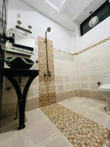 een badkamer met een douche, wastafel en toilet bij UK Hotel in Abbottābād +17 foto's