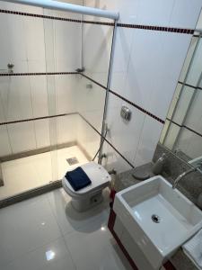 une salle de bains blanche avec toilettes et lavabo dans l'établissement Melhor Apto no Centro ao lado da Praia e Comércio, à Guarapari 16 autres photos