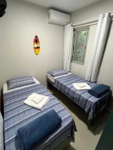 une chambre avec deux lits et une fenêtre dans l'établissement Melhor Apto no Centro ao lado da Praia e Comércio, à Guarapari