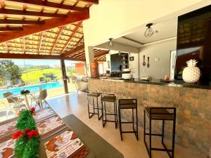a kitchen and living room with a bar with stools at A Casinha in Socorro