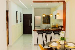 a kitchen with a table and some bar stools at Adèle résidence in Mandanou +3 photos