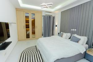 a bedroom with a white bed and a ceiling fan at Adèle résidence in Mandanou