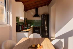 シダリにあるMisemeliのテーブルと椅子、冷蔵庫のあるキッチン