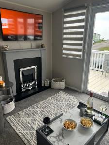 a living room with a fireplace and a table at Ocean view in Heysham