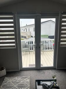 a sliding glass door with a view of a deck at Ocean view in Heysham +1 photo