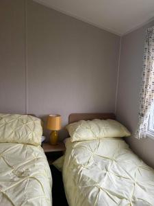 a bedroom with two beds and a lamp on a table at Ocean view in Heysham