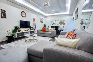 a living room with a couch and a tv at Cherry Signature Condos in Adentan