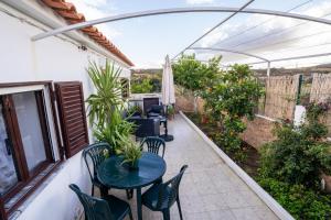 a patio with a table and chairs and an umbrella at Cantinho Alentejano-Rua das Hortas, Corte Pao e Agua in Mértola