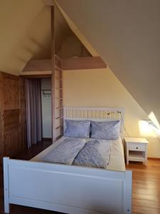 een wit bed in een kamer met een loft bij Haus Bei Der Kirche in Oland