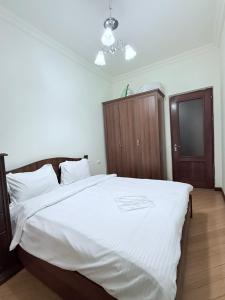 una camera da letto con un letto grande con lenzuola bianche di Republic Square 2 bedroom 2 bathroom a Yerevan Altre 10 foto