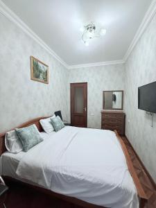 una camera con letto bianco e TV a schermo piatto di Republic Square 2 bedroom 2 bathroom a Yerevan