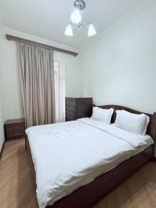 una camera da letto con un letto grande con lenzuola bianche di Republic Square 2 bedroom 2 bathroom a Yerevan