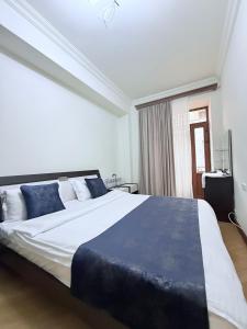 una camera da letto con un grande letto bianco con cuscini blu di Republic Square 2 bedroom 2 bathroom a Yerevan