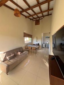 a living room with a couch and a table at Vila Floresta - Arraial D'Ajuda in Porto Seguro
