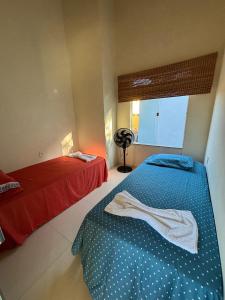 a bedroom with two beds and a window at Vila Floresta - Arraial D'Ajuda in Porto Seguro