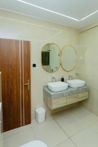 a bathroom with two sinks and a mirror at Adèle résidence in Mandanou
