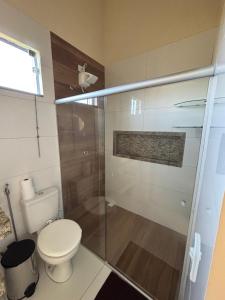 a bathroom with a toilet and a glass shower at Vila Floresta - Arraial D'Ajuda in Porto Seguro +8 photos
