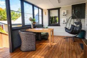 een veranda met een houten tafel en stoelen bij Hidden Gem - St Mary's in Saint Marys