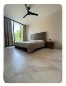 a bedroom with a bed and a ceiling fan at Relajante y acogedor in Tangolunda +9 photos