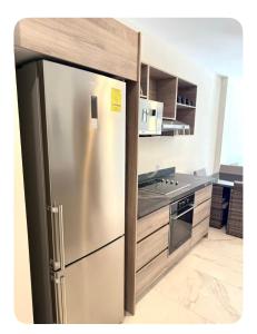 een keuken met een roestvrijstalen koelkast bij Relajante y acogedor in Tangolunda +9 foto's
