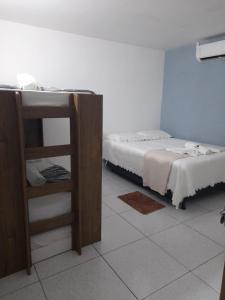 een kamer met 2 bedden en een boekenplank bij Hospedaria Temporarte in Piranhas