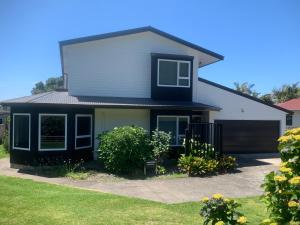 een huis met een zwart-wit bij Ohope Coastal Escape in Ohope Beach