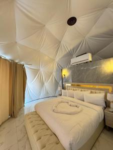 een slaapkamer met een groot bed in een tent bij Rum Plaza Luxury Camp in Wadi Rum