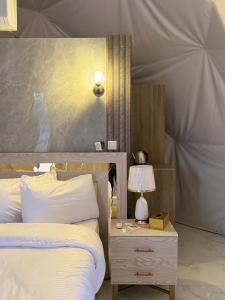 een slaapkamer met twee bedden en een tafel met een lamp bij Rum Plaza Luxury Camp in Wadi Rum +143 foto's