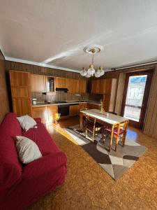 un salon avec un canapé rouge et une table dans l'établissement Casa Bruna 2 a 25 minuti da Bormio e 15 min da Tirano, à Vervio