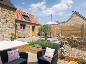 d'une terrasse avec 2 chaises et un mur en pierre. dans l'établissement Chambres Le Penty, à Pleumeur-Bodou