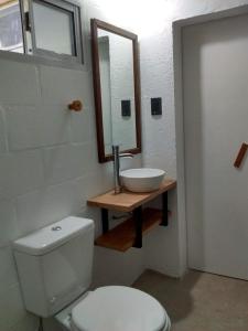 a bathroom with a toilet and a sink and a mirror at Aloja Merlo in Merlo
