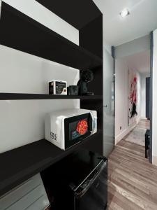 een magnetron op een plank in een keuken bij Suiite de lujo en Sol M in Madrid