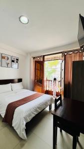 een slaapkamer met een bed, een bureau en een raam bij Tintaya Hotel Chachapoyas in Chachapoyas
