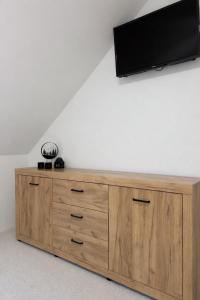 - une télévision à écran plat sur une commode en bois dans l'établissement Apartmánový dom Adriana, à Zuberec
