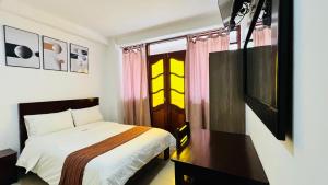 查查波亚斯Tintaya Hotel Chachapoyas的一间卧室，里面有一张床、一张桌子和一扇窗户。
