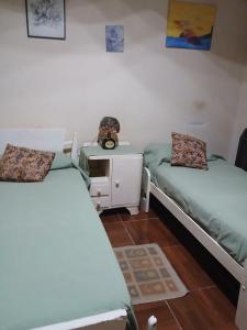 a room with two beds and a desk with a night stand at Las Gemelas in Rosario