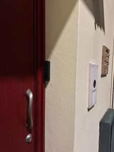 una porta rossa con una maniglia di metallo su un muro di Casa Sorgata a Noale
