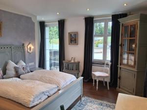a bedroom with a large bed and a window at Die schlafende Goass in Bischofswiesen
