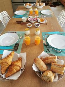 a table with plates of bread and glasses of orange juice at Chambres Le Penty in Pleumeur-Bodou