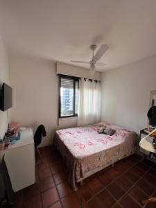 una camera da letto con un letto e una finestra di Apartamento com suíte Praia Grande Torres a Torres