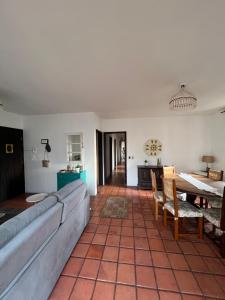 un soggiorno con un divano e un tavolo di Apartamento com suíte Praia Grande Torres a Torres