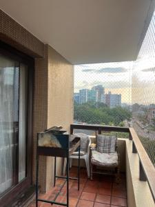 un balcone con tavolo e sedie su un edificio di Apartamento com suíte Praia Grande Torres a Torres