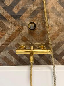 ein goldener Schlauch, der an der Decke befestigt ist in der Unterkunft Apartament Centrum Warszawy Pereca in Warschau + 12 Fotos