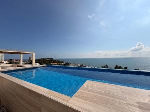 a swimming pool with the ocean in the background at Luxury 2-Bedroom Apartment with amazing view - Infinity Pool and Rooftop in Building in Veracruz